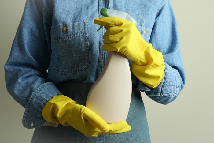 woman holding spray bottle of detergent