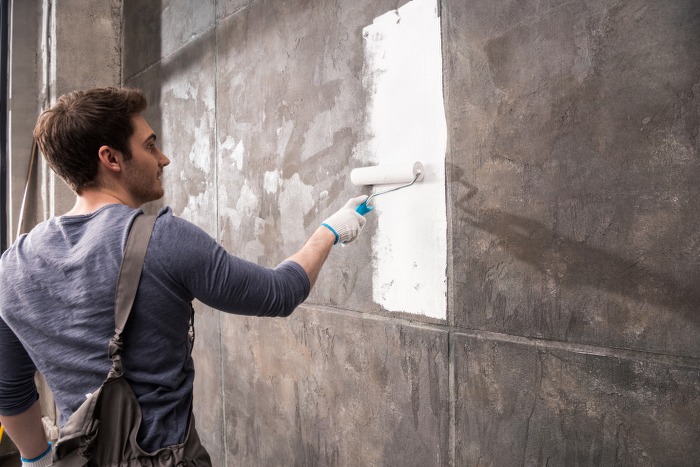 young man painting wall